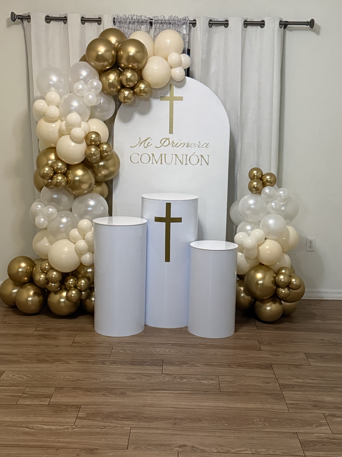 White and gold balloons framing a First Communion display
