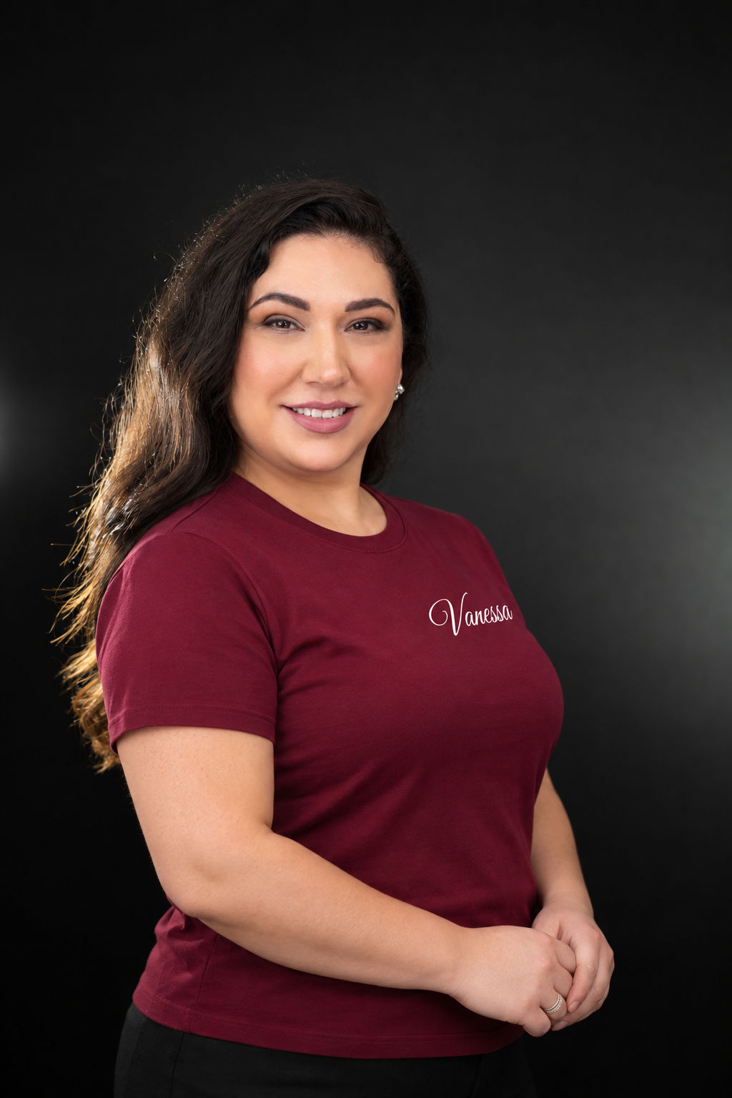 Vanessa Alvarado wearing a burgundy Adorn Designs shirt with her name in white script